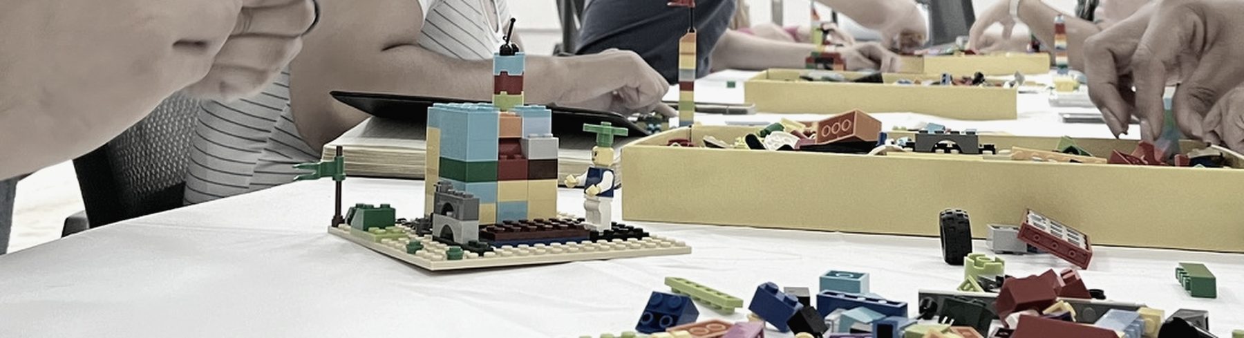 Mesa de trabajo con modelos construidos y piezas sobre la superficie durante una sesión.